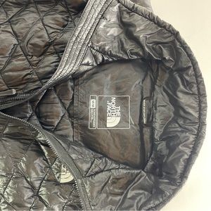 The Northface lightweight shiny black vest with side pockets